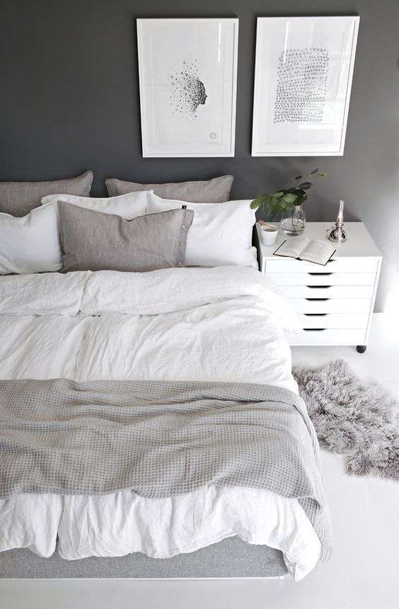 Cette chambre propose des tons de gris et de blanc ainsi que deux tableaux minimalistes