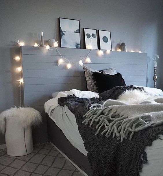 Chambre grise avec tête de lit éclairée et des cadres