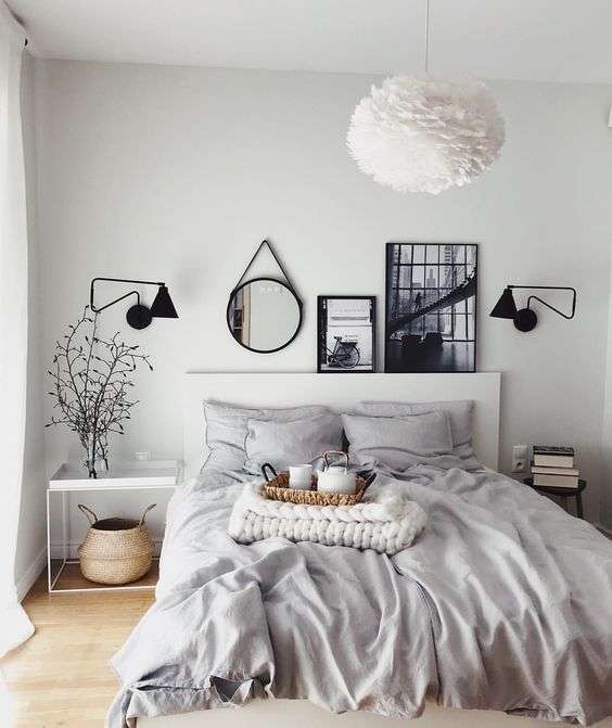 Chambre grise très claire avec cadres, miroirs et plantes pour un contraste accru