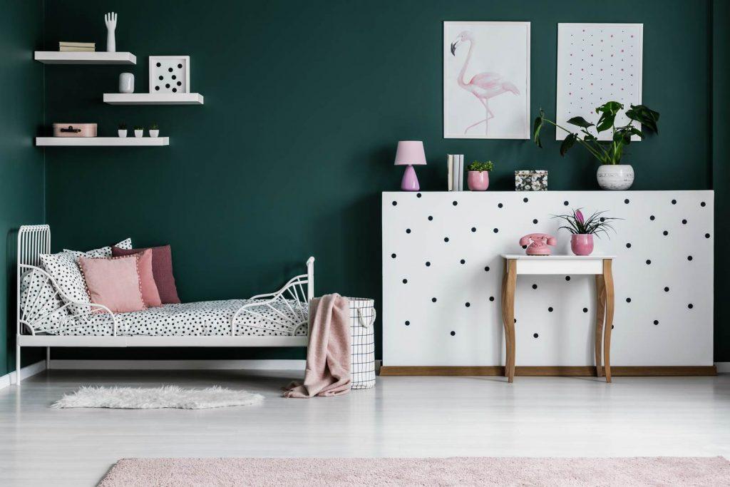 Chambre avec mur vert foncé et accessoires rose