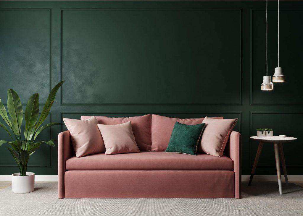 Salon mur vert foncé avec canapé rose